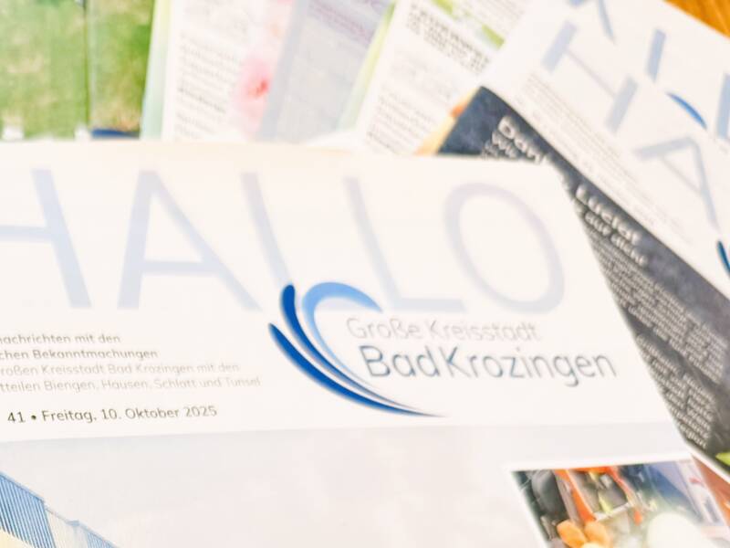 Mehrere übereinanderliegende Ausgaben der Stadtzeitung Hallo Bad Krozingen 
