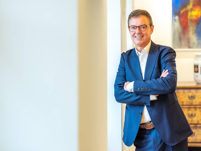 Oberbürgermeister Kieber lehnt lächelnd an einer Wand und wendet sich den Betrachter des Bildes zu.