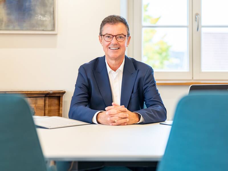 Oberbürgermeister Kieber sitzt lächelnd an einem großen Besprechungstisch