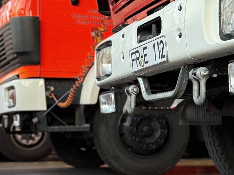 Rote Feuerwehrautos mit der Aufschrift "Feuerwehr Bad Krozingen" stehen in einer Halle.